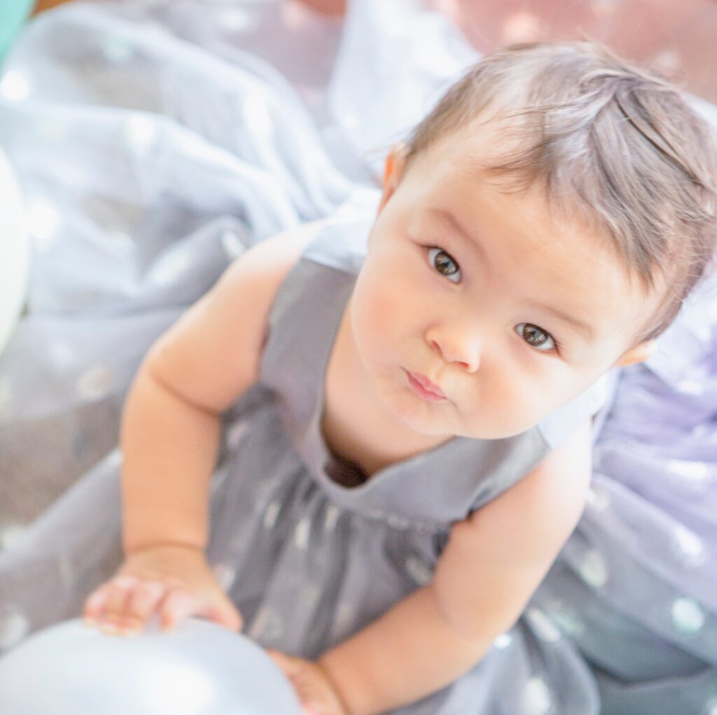 Baby girl wearing party dress with balloon
