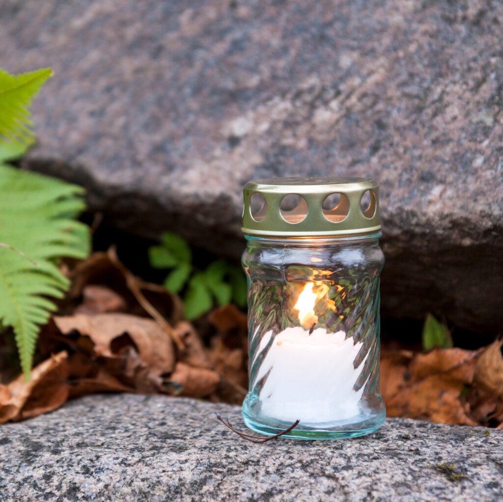 Candle standing on tombstone and burning